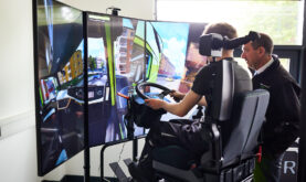 Boston College Learner using DTLA Driving Simulator, being assisted by Boston College Staff Member