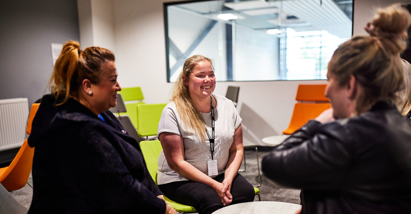 Boston College Learners smiling in conversation around a table