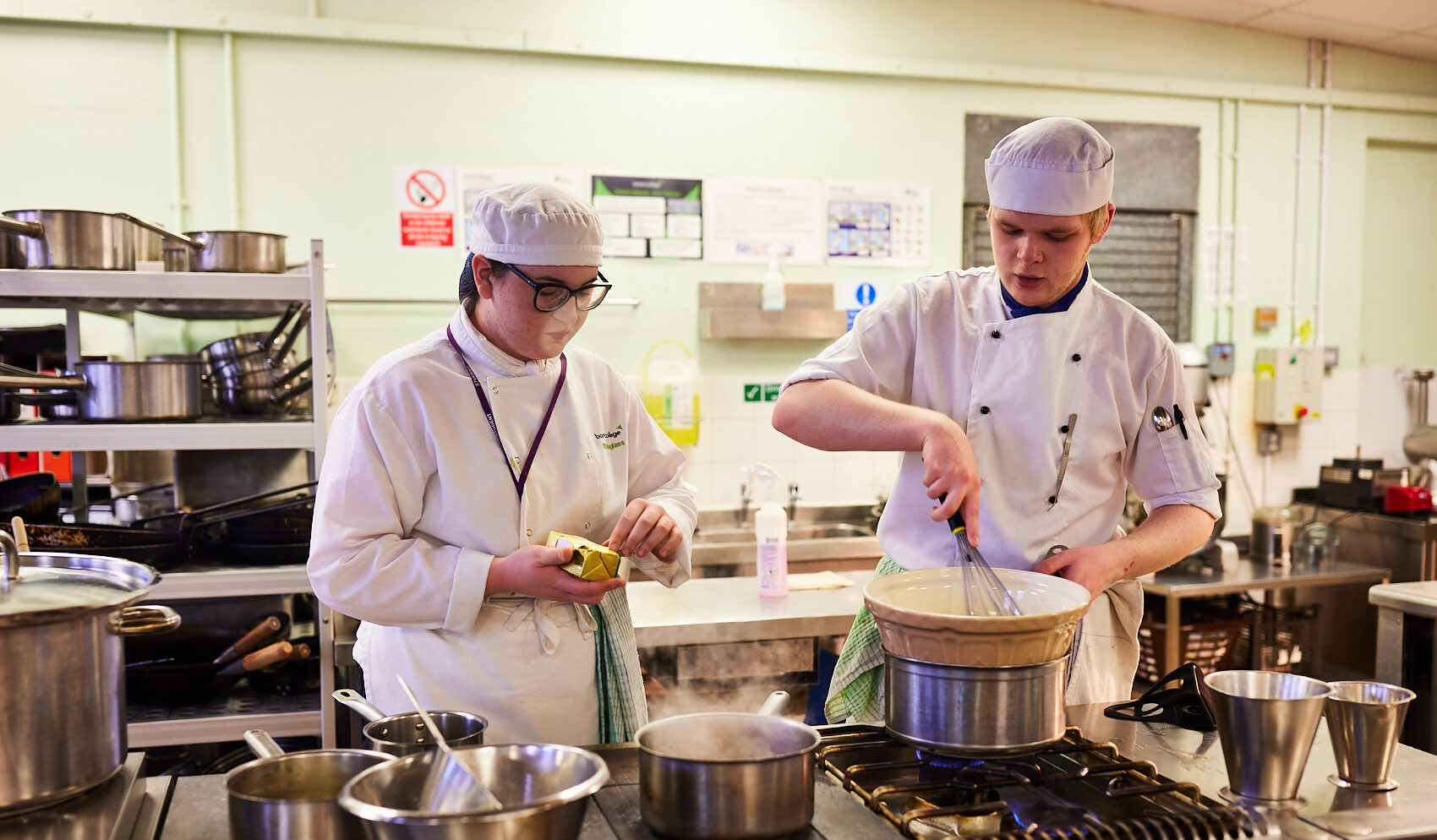 2 Boston College Catering Learners preparing food in the Boston College Learner Kitchens