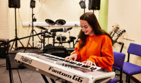 Boston College Learner creating music on electric Keyboard