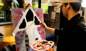 Boston College Art and Design Learner, painting, using an easel and paint tray