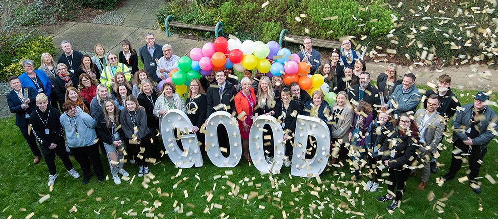 Boston College Staff and Students stood infront of a rainbow balloon arch and GOOD letters with confetti cannons announcing the Good Ofsted Grading