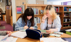 2 Boston College Learners working together, sat at desk together