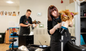 2 Boston College hairdressing Learners, working on manekin heads.