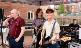 Boston College Learners performing in a band outside the Sam Newsome Centre.