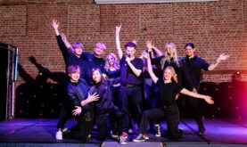 Boston College Performing Art Group, posing on stage in the Sam Newsom Centre