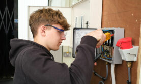 Boston college Electrical Student working in wall mounted fuse box