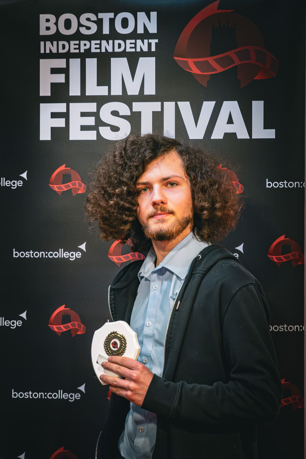 Boston College Learner posing with award at Film Festival 2024