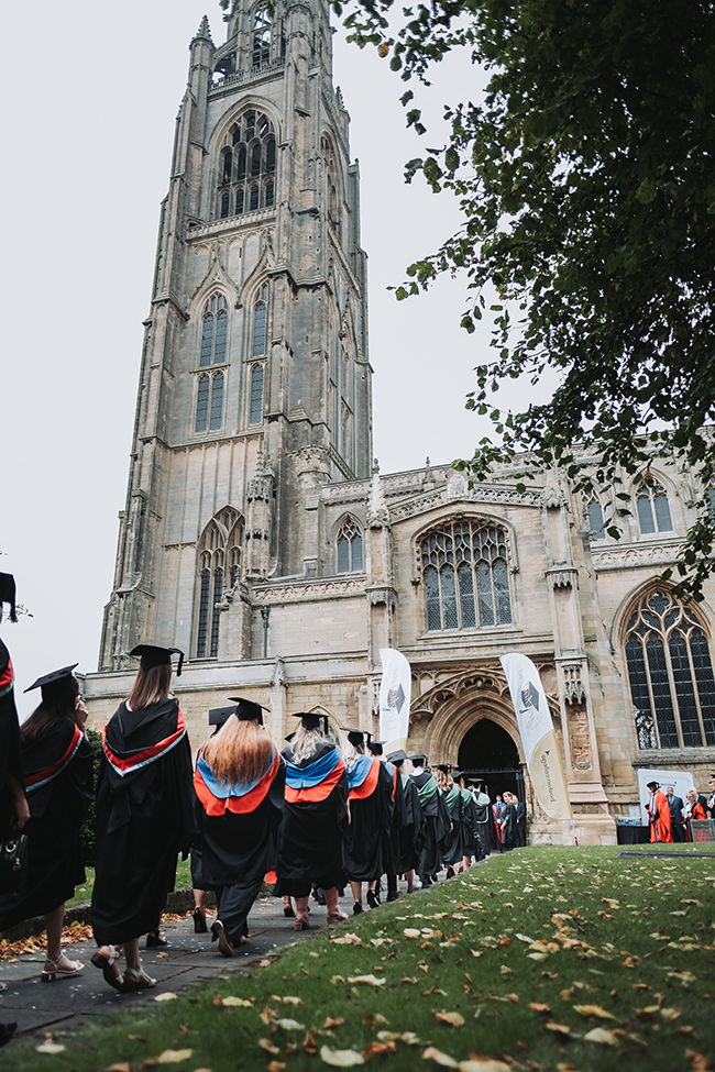Boston College Higher Education Graduation - Graduates walking away from the camera into The Stump